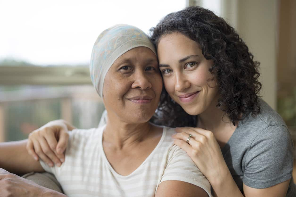 Ethnic young adult female hugging her mother who has cancer